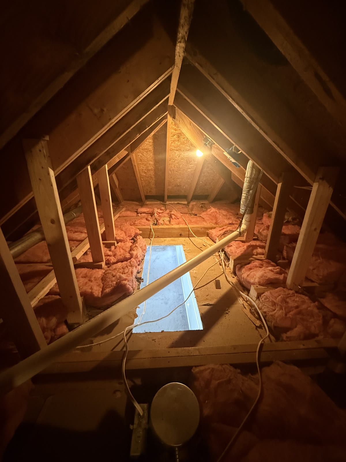 Hallway during construction with the ceiling opening cut and lumber staged.