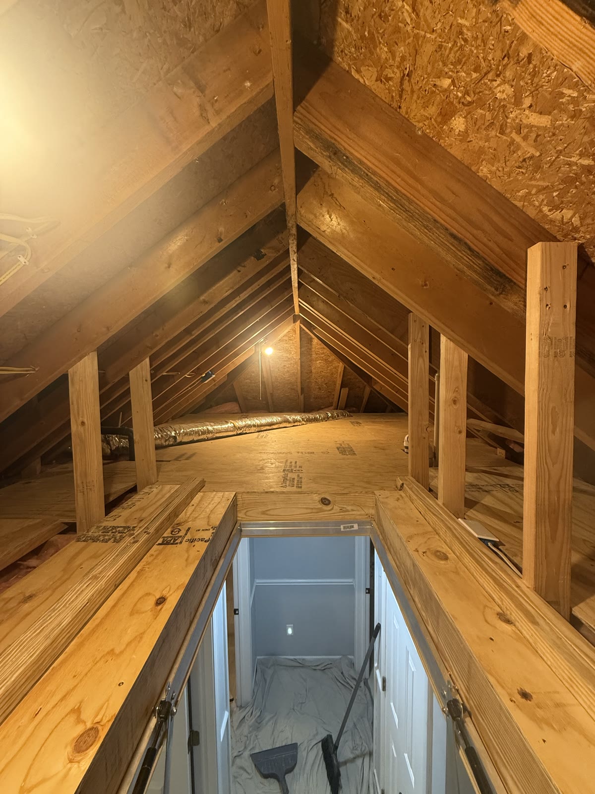 Plywood storage platform and support posts built across the attic floor.