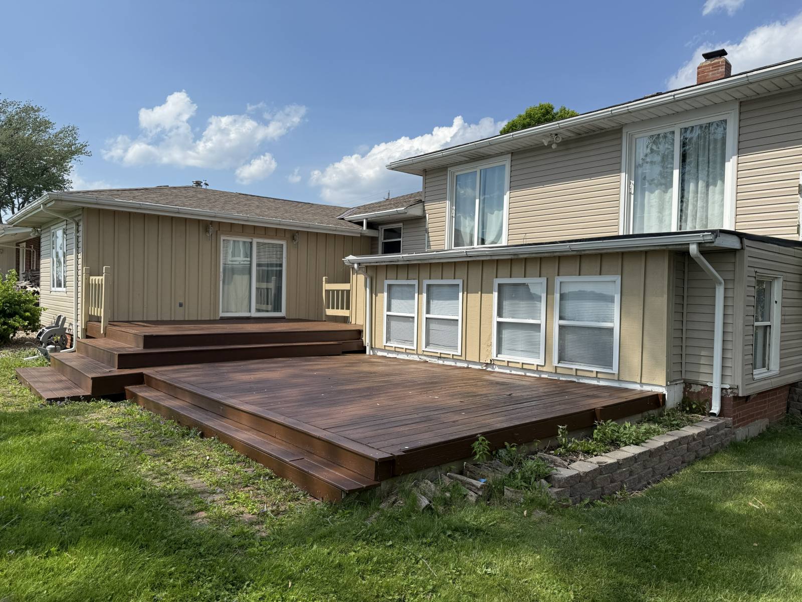 The same backyard deck after repainting, with an even, rich finish and no visible peeling