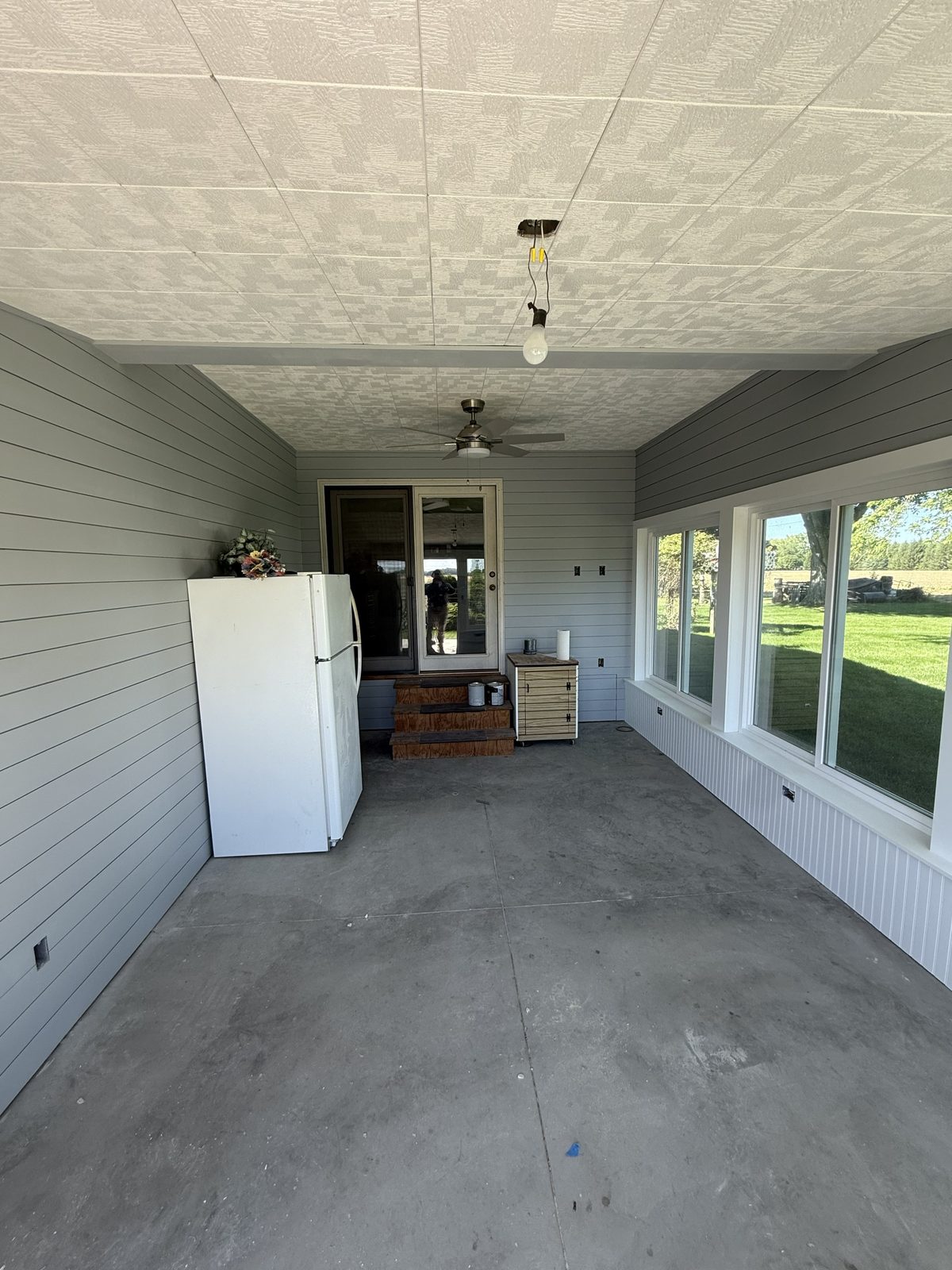 Finished sunroom remodel with shiplap walls and a wall of windows